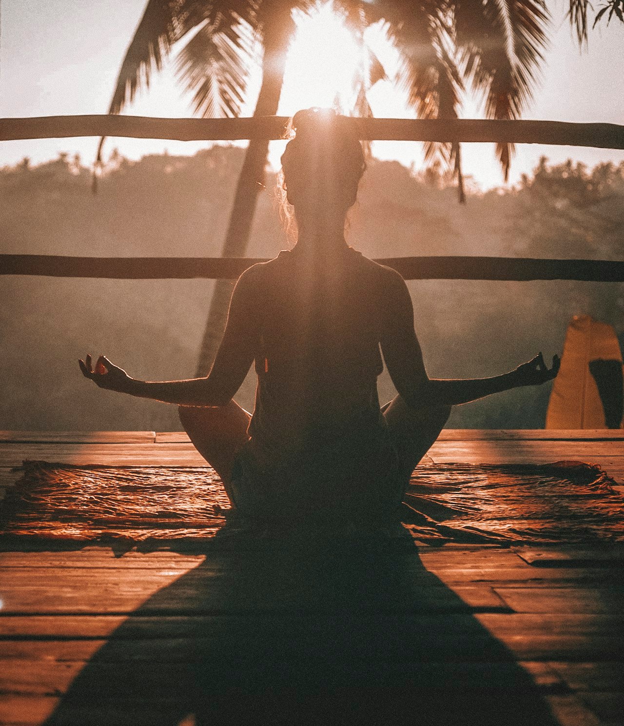 A calm figure practicing mindful breathing on a sunlit wooden floor, evoking stress recovery and a return to baseline